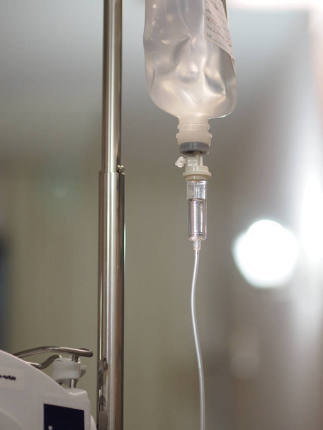 Zouttoedieningsapparatuur van de patiënt, vloeistof gevulde set IV oplossing druppelinfuus in het ziekenhuis, zout water - Foto, afbeelding