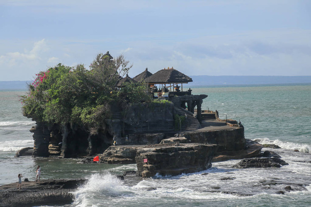 Belo Tanah Lot Temple em Bali Indonésia cena épica natureza e arquitetura de fundo. Templo de Peregrinação de Pura Tanah Lot está empoleirado dramaticamente em uma grande rocha costeira
. - Foto, Imagem
