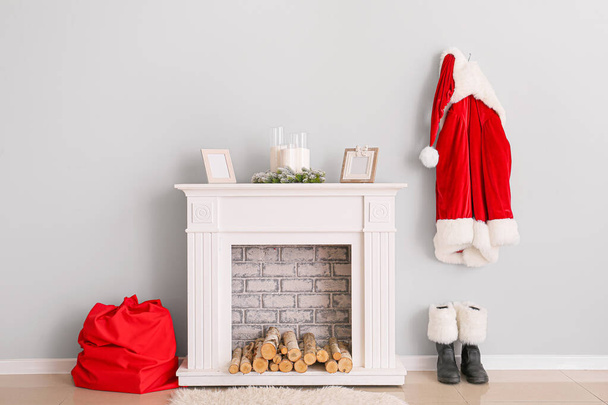 Święty Mikołaj kostium wiszący na ścianie w pobliżu kominka w pokoju - Zdjęcie, obraz