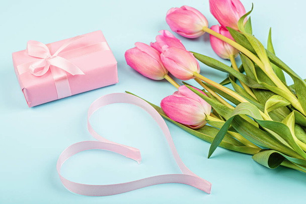 tulips and gift box on blue. Background for womens day, 8 March Valentines day, 14 february. Flat lay style, top view, mock up, template, overhead. Greeting card - Fotografie, Obrázek