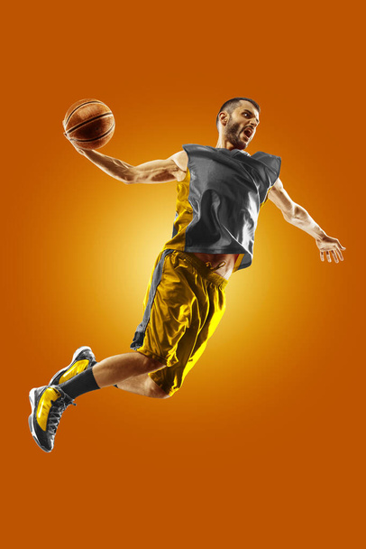 bright professional basketball player on an orange background - Фото, зображення