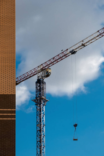 Building crane lifts building materials. Construction, building a house. - Fotografie, Obrázek