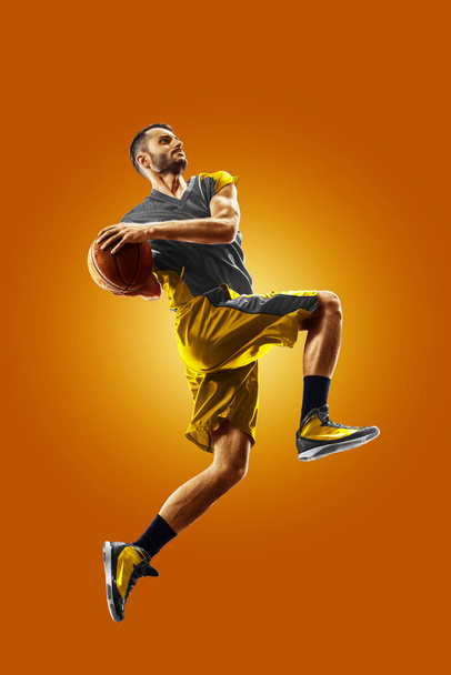 bright professional basketball player on an orange background - Фото, зображення