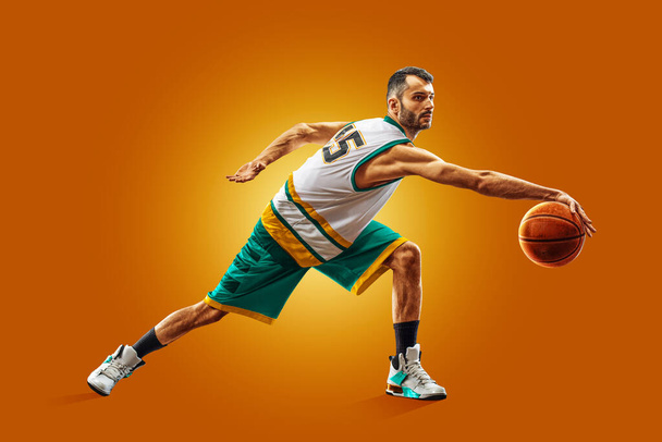 bright professional basketball player on an orange background - Fotoğraf, Görsel