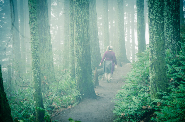 Senior dame wandelend over de Poo Poo Point Chirico Trail in Washington State, Amerika. Mistige route in het weelderige bosrijke berglandschap - Foto, afbeelding