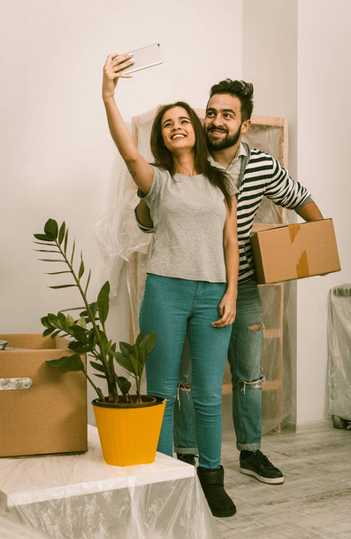 Man and woman in casual clothes standing in new home after relocation, forwarding to new life. - Foto, Imagen