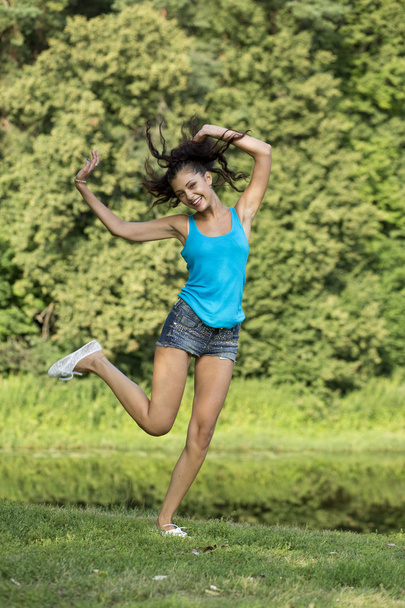 Beautiful girl jumping for joy in a summer park - Foto, Imagem