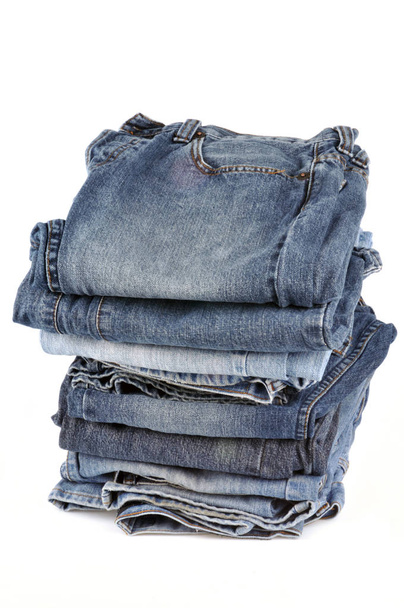 Синяя джинсы сложены и сложены крупным планом на белом фоне
  - Фото, изображение