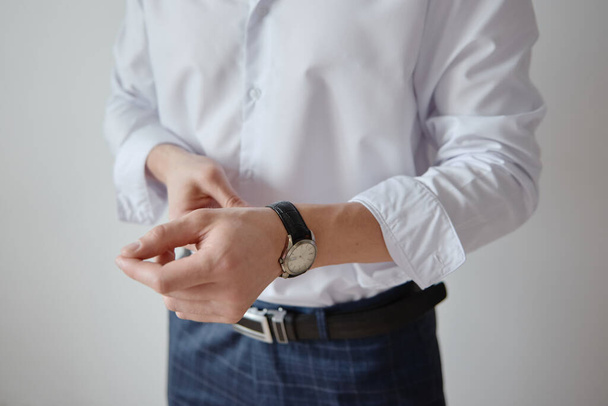 Businessman looking at watches on his hand indoors, copy space. Man in white shirt checking time from luxury wristwatches. Watch on hand. Groom wedding preparation - Zdjęcie, obraz