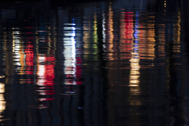 АМСТЕРДАМ, НИДЕРЛАНД - старые городские каналы отражают красные огни на воде
  - Фото, изображение