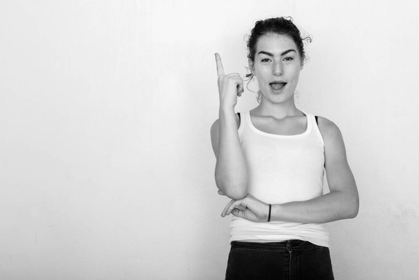 Studioaufnahme von jungen schönen Teenager-Mädchen isoliert vor weißem Hintergrund in schwarz-weiß - Foto, Bild