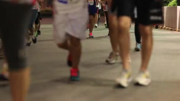 Низкий участок марафонской беговой дорожки, ноги людей на городской дороге - Кадры, видео