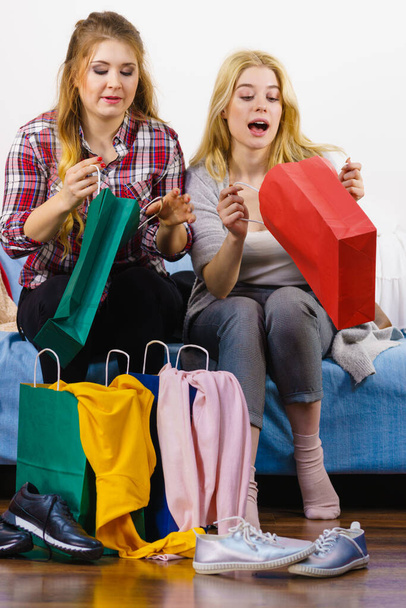 Two happy joyful women having fun after shopping, picking outfit in closet. Female friends fooling around. - Foto, imagen