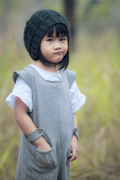 retrato de niños asiáticos con capucha de lana de pie en el parque verde
 - Foto, Imagen