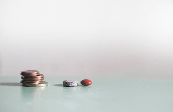 Grey and Orange drug medicine pills closeup with coin on light background with copyspace. - Fotografie, Obrázek