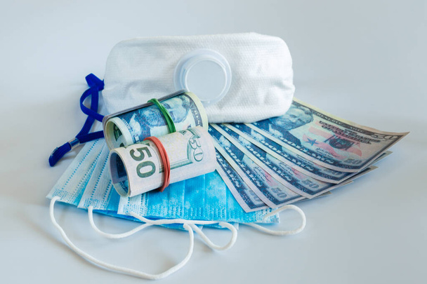 Maschere mediche e banconote da 50 dollari come simbolo di prezzi più elevati per proteggere le vie respiratorie dai virus
. - Foto, immagini