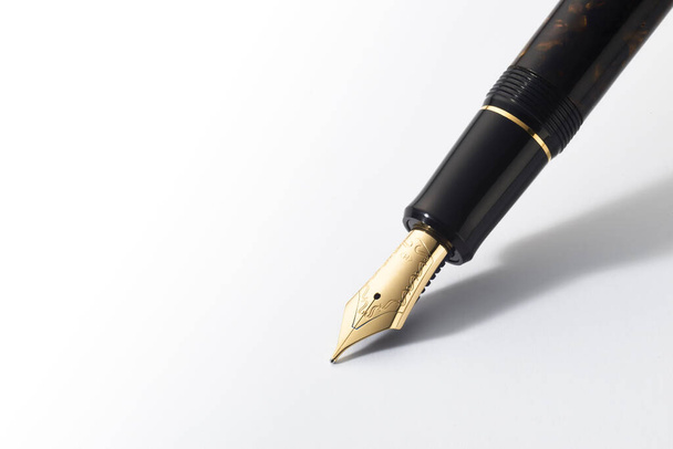 Pluma estilográfica con pluma de oro en detalle en posición de escritura - Foto, imagen