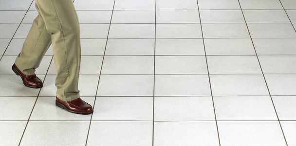 Низкая часть мужских ног на белом фоне плитки с копировальным пространством - Фото, изображение