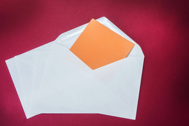 One opened white envelope on the red background - Foto, Imagem