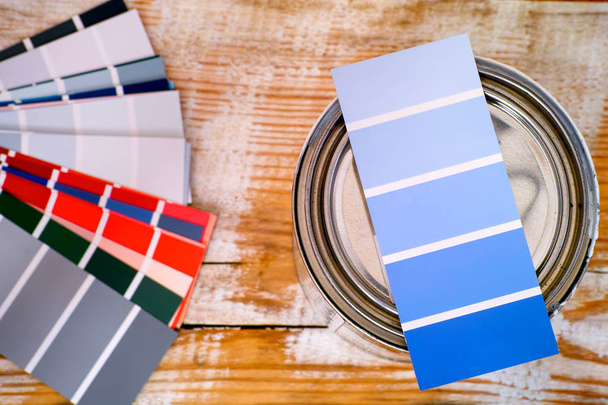 Muestra de color azul para teñir en pintura puede estar de pie sobre fondo de madera con algunas muestras de color. Primer plano
. - Foto, Imagen