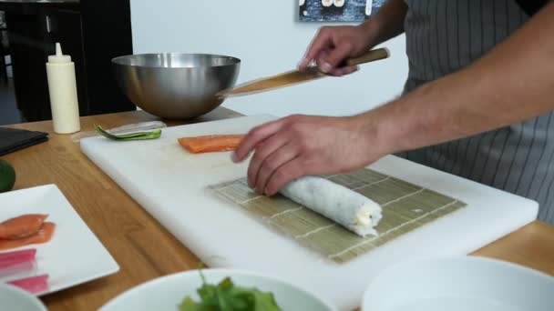 Sushi master preparing fresh and tasty sushi rolls in Japanese restaurant. Concept: Rolling a sushi roll on bamboo mat.Sushi making process, cutting ingredients - Πλάνα, βίντεο