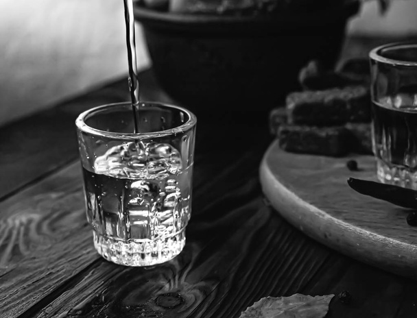 Traditionelles Getränk Wodka in Gläsern, mit einem Snack in Form von Aufschnitt und Speck, Gurken, Konservierung. Russische Festtafel. - Foto, Bild