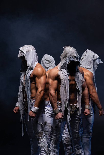 Four muscular gothic man standing shirtless on black background. Concept of mystery and secret - Foto, Bild