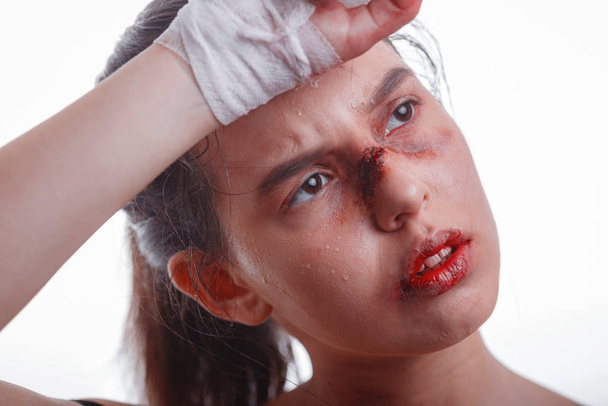 Młoda kobieta z siniakami na twarzy ofiara przemocy domowej. Kobieta w krwawym bandażu na pięściach, gotowa do walki. Idea niezależności, feminizmu i obrony ich praw. Klub walki - Zdjęcie, obraz