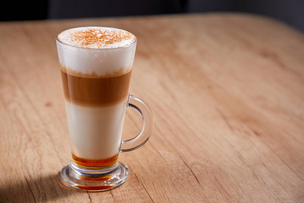 latte macchiato met siroop op tafel, close view  - Foto, afbeelding