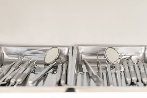 varios juegos de instrumentos dentales en bandejas situadas una al lado de la otra
 - Foto, Imagen