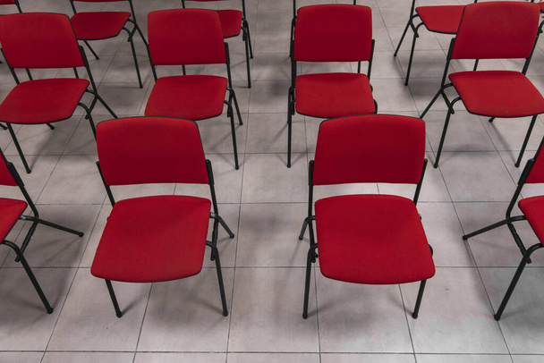 rusztikus konferenciaterem felülnézet piros székekkel sorok csempén padló háttér emberek nélkül itt - Fotó, kép