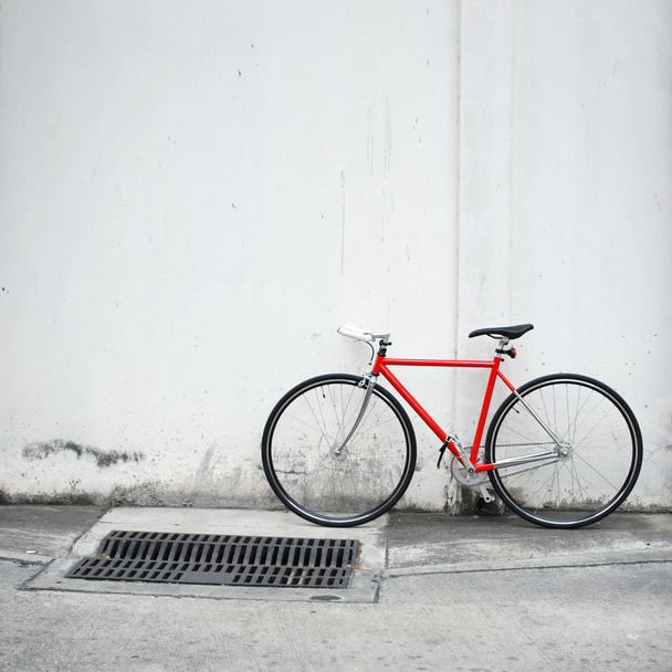 Modern red bicycle leaning on white wall - Photo, Image