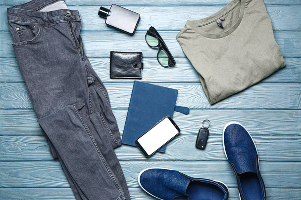 Roupas masculinas elegantes com acessórios e telefone celular em fundo de madeira
 - Foto, Imagem