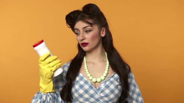 Pin up mujer en guantes de goma que sostienen los suministros de limpieza
 - Metraje, vídeo