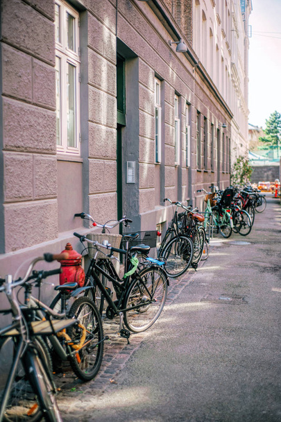 Row of parked colorful bikes on a street. Healthy lifestyle - Zdjęcie, obraz