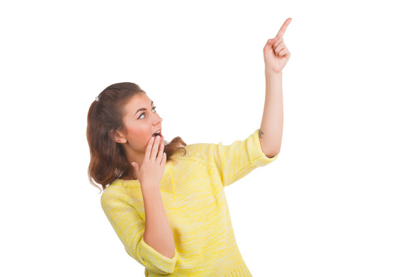 Young woman pointing at something on white background - Foto, afbeelding
