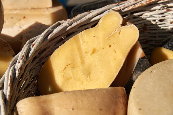 Diferentes variedades de queso artesanal en una canasta de mimbre
 - Foto, imagen