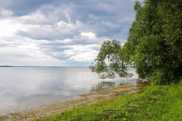 Orilla de un gran lago o mar en un día nublado
 - Foto, Imagen