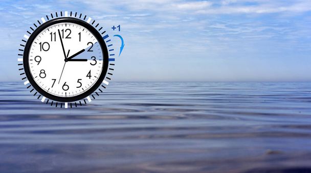 Daylight Saving Time (DST) Relógio de parede na paisagem do mar. Vire o tempo para frente. Foto abstrata da mudança de tempo na primavera
. - Foto, Imagem