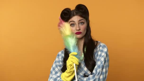 Worried pin up woman in rubber gloves holding duster - Footage, Video