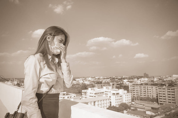 Mujer asiática con máscara enferma y contaminación en la ciudad. Coronavirus y contaminación atmosférica pm 2.5 concepto
. - Foto, Imagen