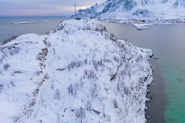 Aerial view of Lofoten islands and lake or river, Nordland county, Norway, Europe. White snowy mountain hills and trees, nature landscape background in winter season. Famous tourist attraction. - Фото, изображение
