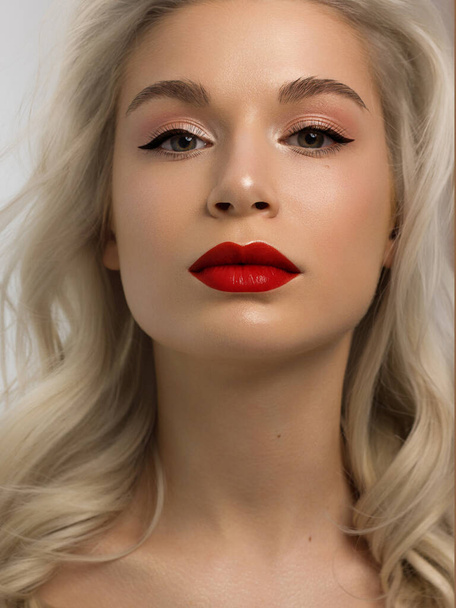 Closeup portrait of a woman with developing straight hair. Sweet tender young girl blonde. Red lipstick, transparent clean skin. Skin care natural cosmetics in the spa salon or cosmetology. - 写真・画像