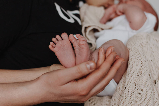 Madre e padre che tengono i piedi del bambino in mano
 - Foto, immagini