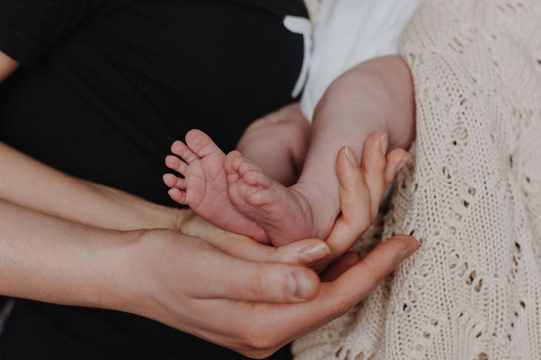 Mother and father holding baby feet in hands - 写真・画像