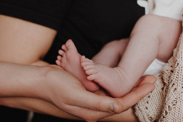 Mother and father holding baby feet in hands - Foto, afbeelding
