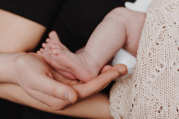 Mother and father holding baby feet in hands - Photo, Image