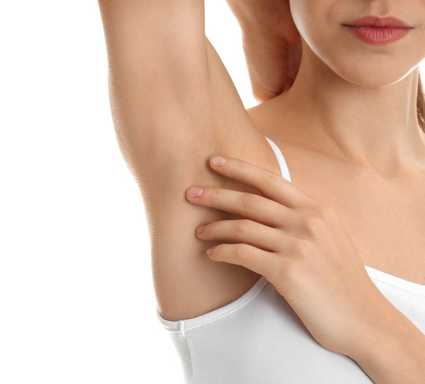 Young woman showing armpit with smooth clean skin on white background, closeup - Fotó, kép