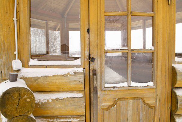 Η ρουστίκ καλοκαιρινή βεράντα είναι κλειδωμένη το χειμώνα. Χειμώνας Arkhangelsk περιοχή. - Φωτογραφία, εικόνα