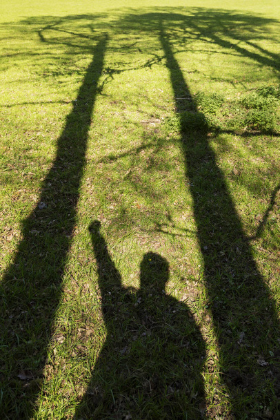 personen schaduw in een groen veld - Foto, afbeelding